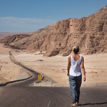 Traveler walking along a desert road in Egypt