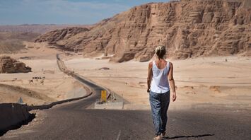 Traveler walking along a desert road in Egypt