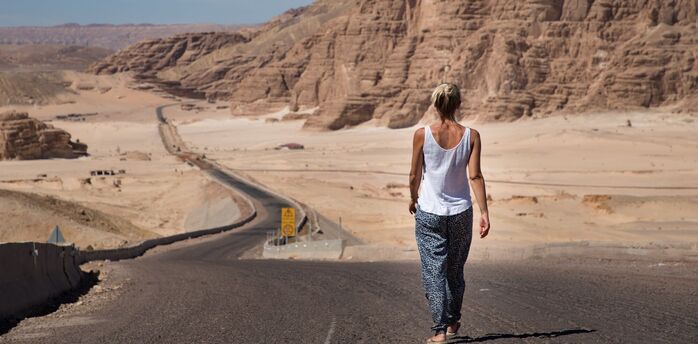 Traveler walking along a desert road in Egypt