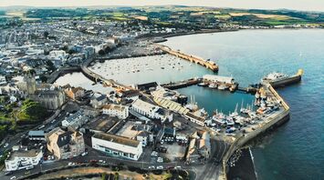 Aerial view of Penzance harbor and town, showcasing boats docked and surrounding buildings
