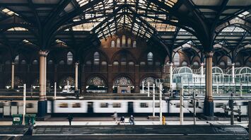 Interior of London Liverpool Street Station showcasing the architectural design and moving train