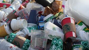 A pile of discarded coffee cups and food containers