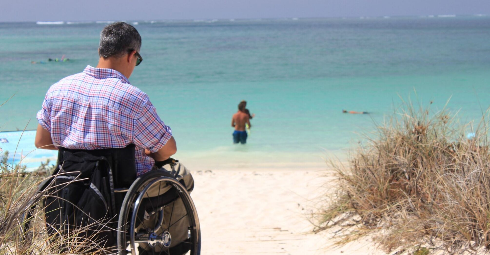 Man in a wheelchair at a beach