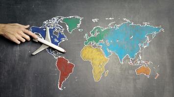 Toy airplane over a chalk-drawn world map