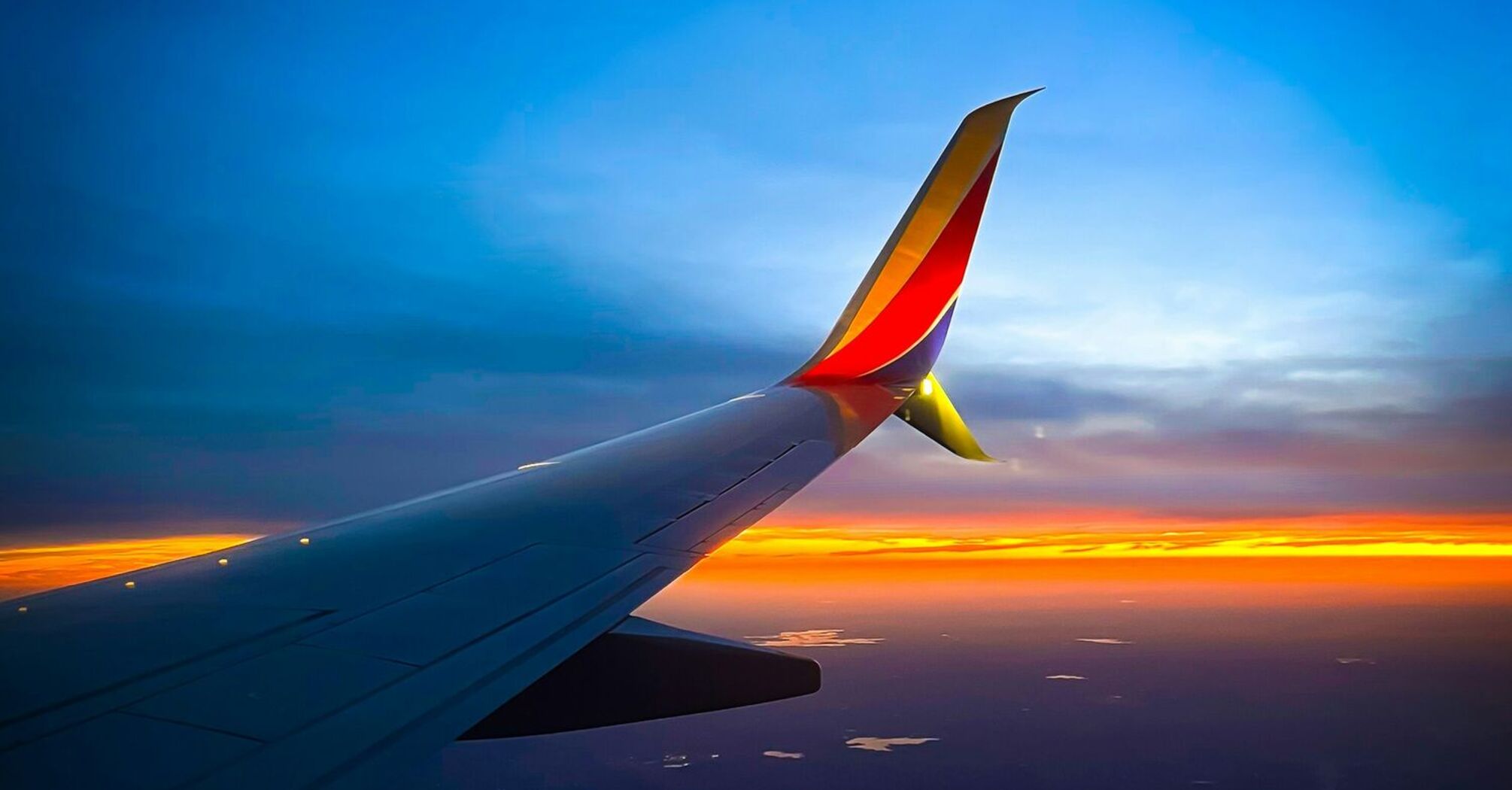 View from an airplane window during sunset with Southwest Airlines wing