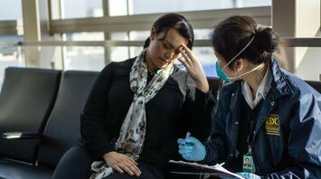 A woman receives medical care from a CDC employee