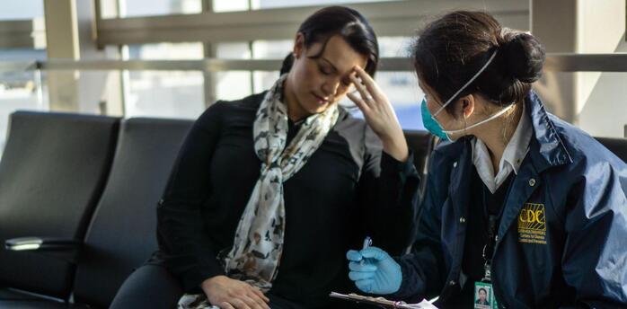 A woman receives medical care from a CDC employee