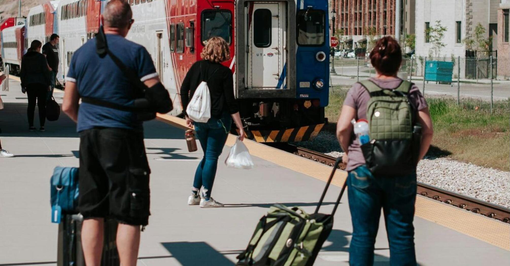 Passengers with luggage wait for the train at the station