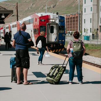 Passengers with luggage wait for the train at the station
