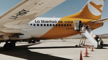FlyBondi Boeing 737-800 on the tarmac with boarding stairs and safety cones