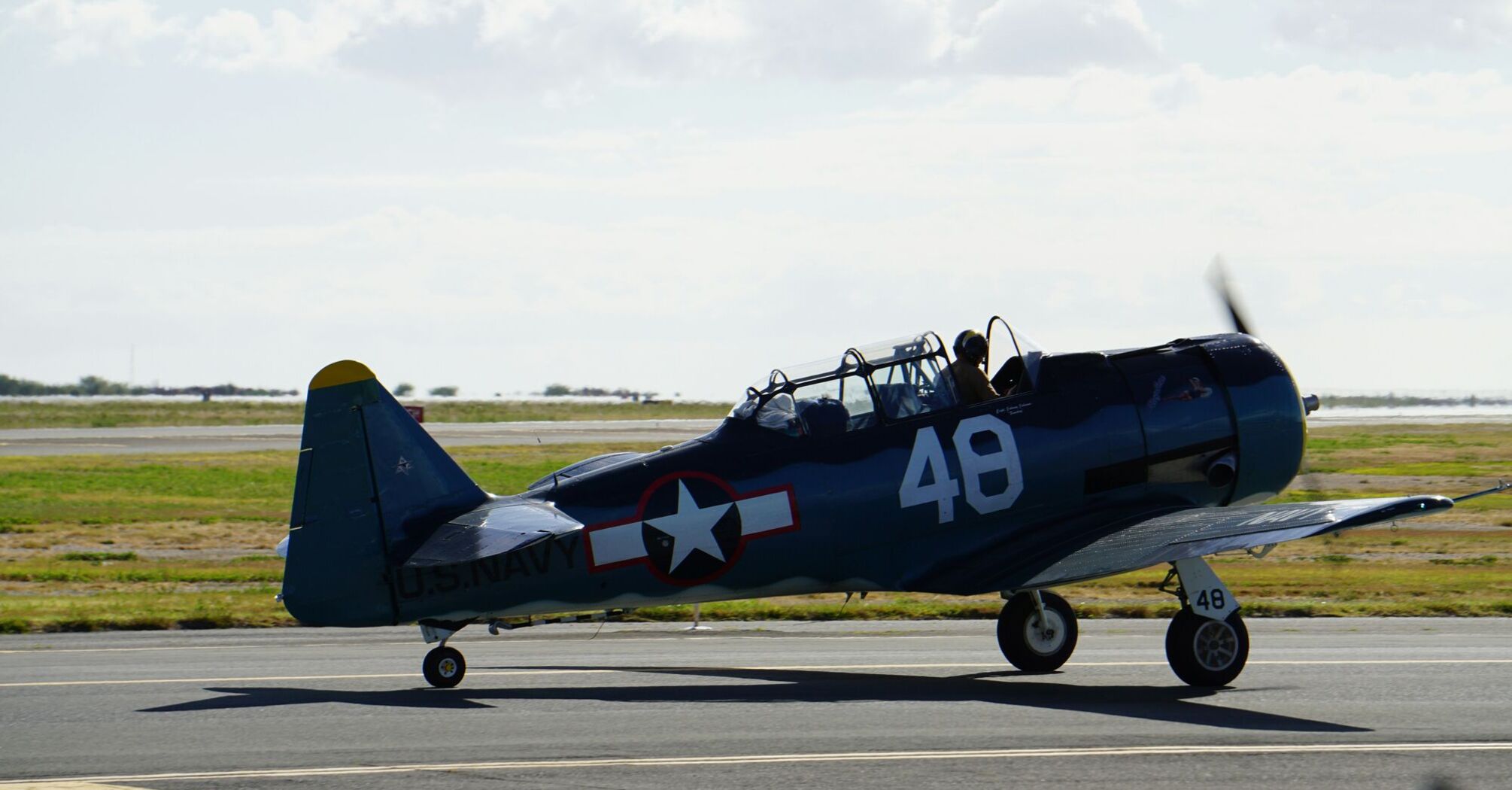 blue and red fighter plane on gray asphalt road during daytime