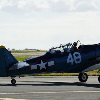blue and red fighter plane on gray asphalt road during daytime