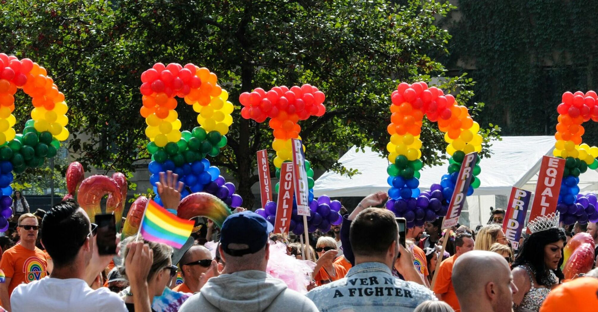 Crowd with rainbow pride balloon decorations