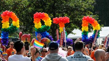 Crowd with rainbow pride balloon decorations