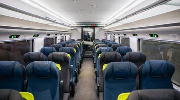 Interior of an empty Eurostar train carriage with rows of seats