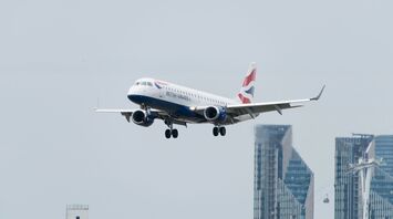 white red and blue airplane above buildings