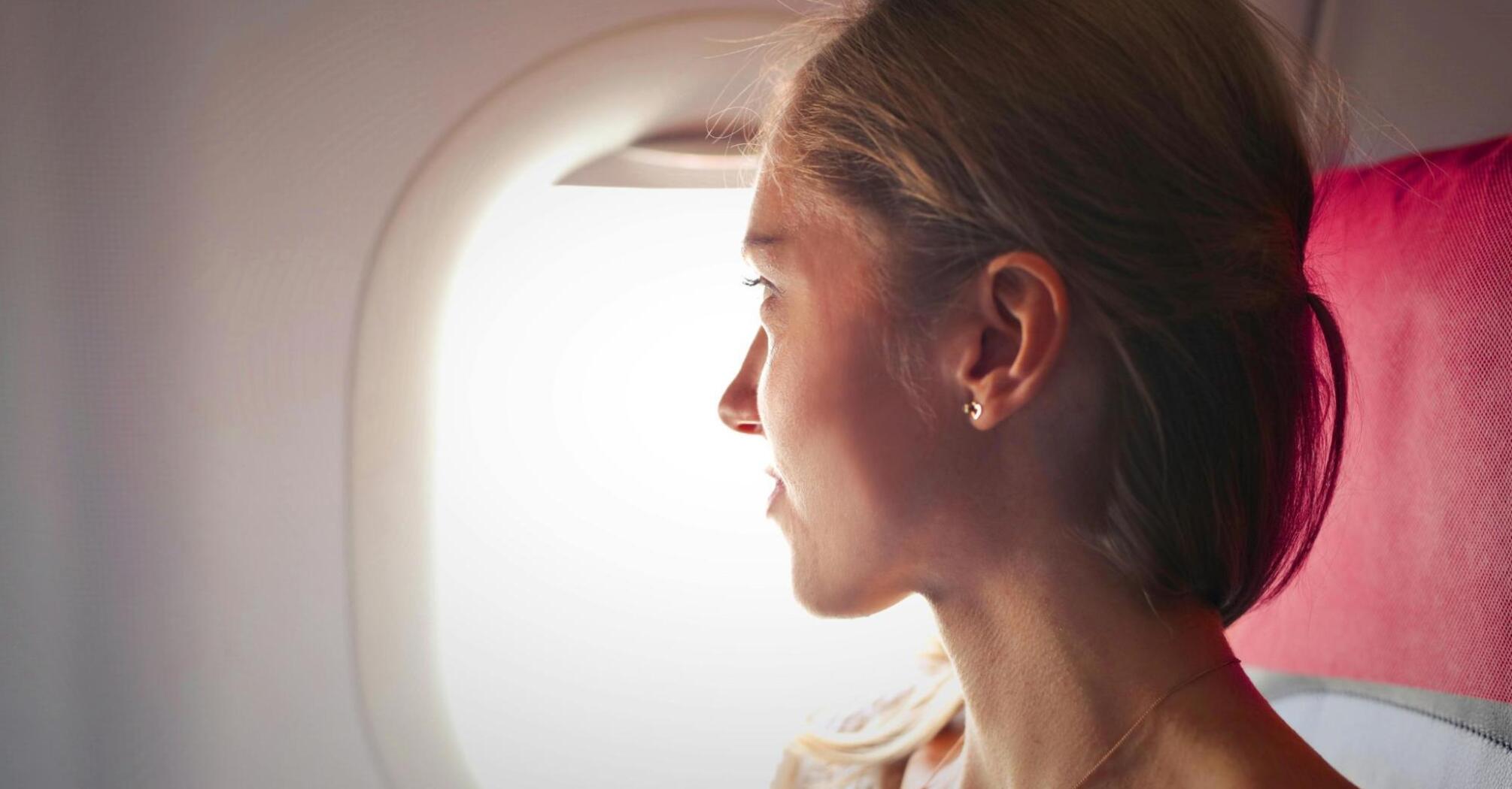 Woman sitting in the plane looking in the window
