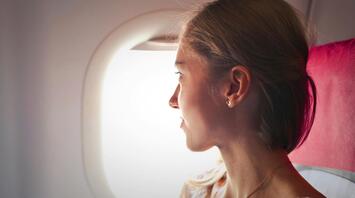 Woman sitting in the plane looking in the window