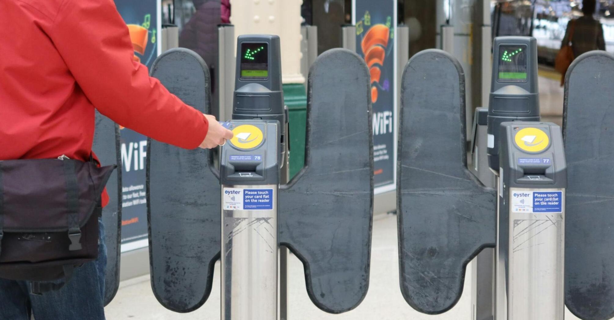 Person using a smart card to enter through a train station turnstile