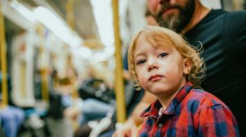 A boy with his father in the subway, sitting on a bench