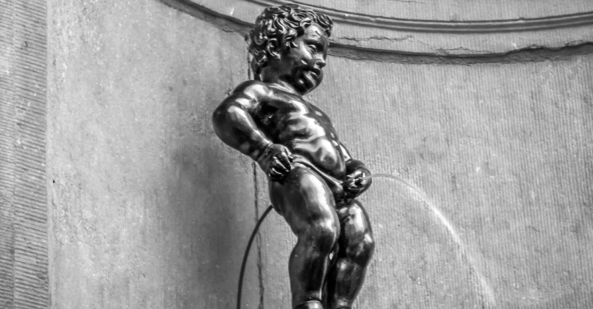 A bronze statue of a little boy urinating