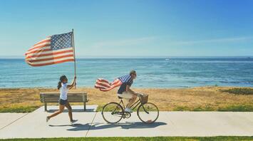 People with US flags celebrating Independence Day on the seashore