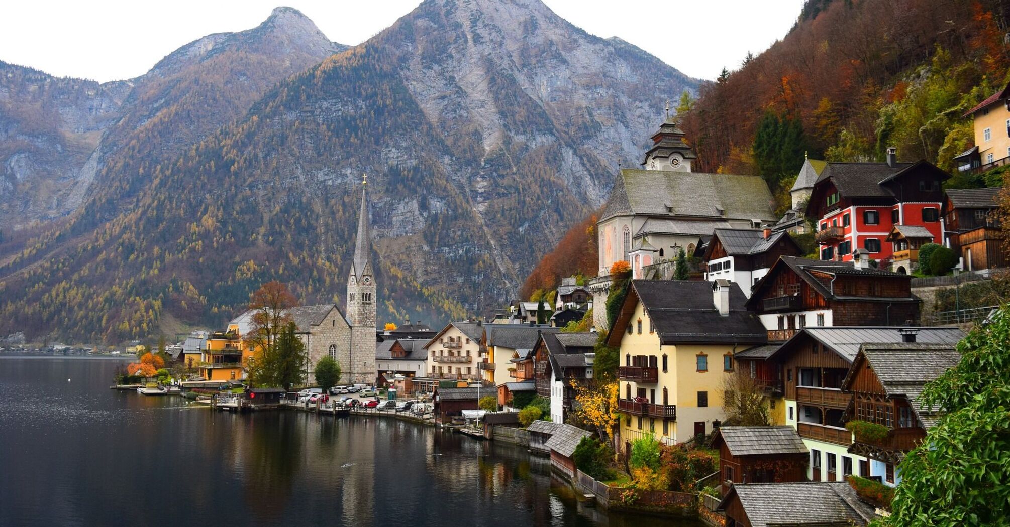 Scenic view of a lakeside village with traditional European architecture and mountainous background