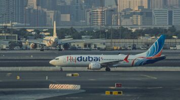 Flydubai airplane on runway with city skyline in the background