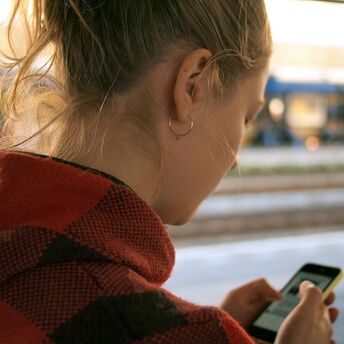 Woman using app on her phone at the train station