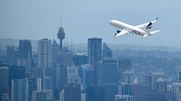Rex Airlines aircraft taking off with city skyline in the background