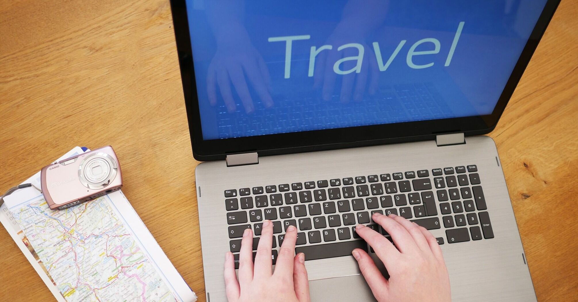 Person booking travel online with laptop