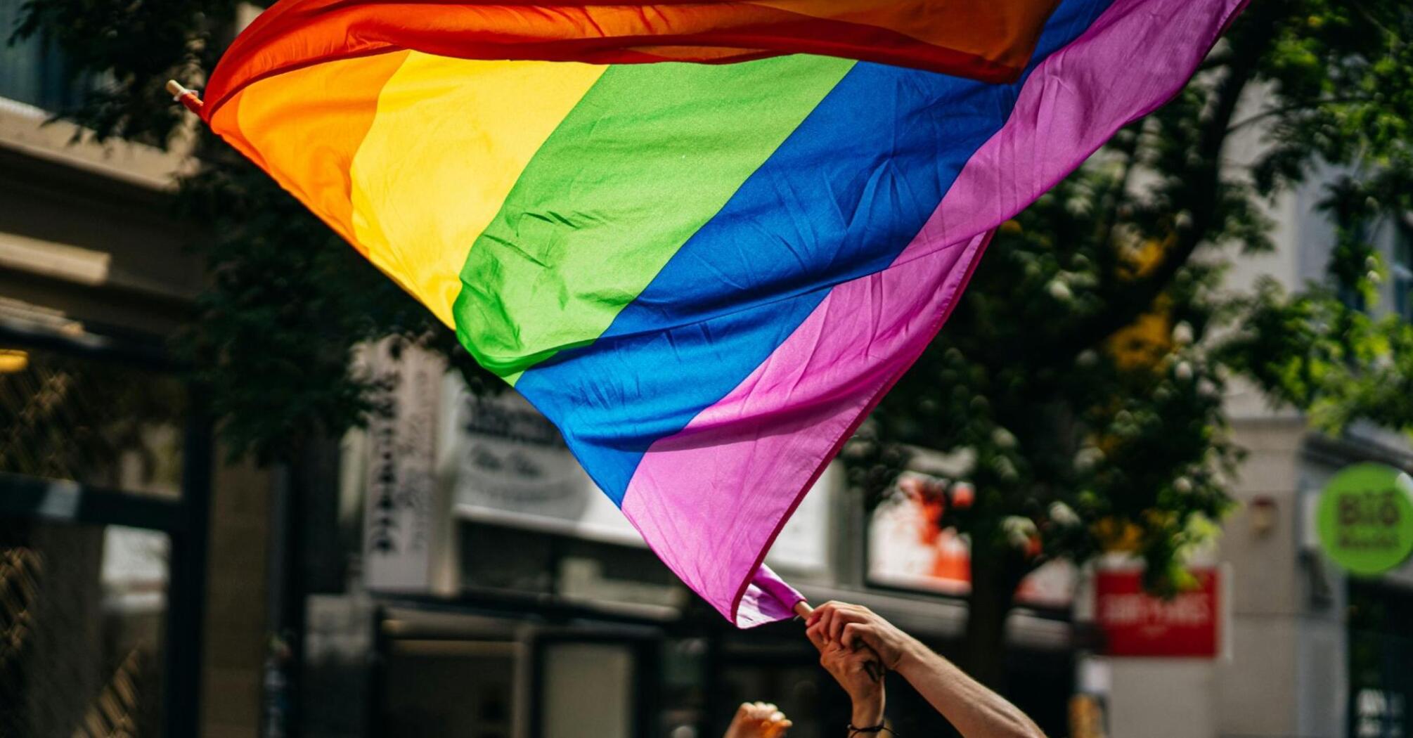 An LGBTQ+ rainbow flag at a demonstration in the city