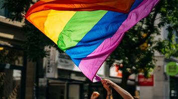 An LGBTQ+ rainbow flag at a demonstration in the city