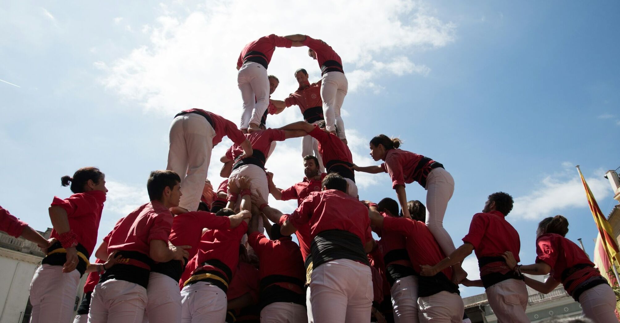 A group of people building a human tower outdoors