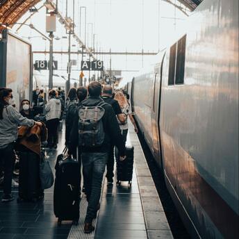 Passengers with luggage on the platform near a high-speed train