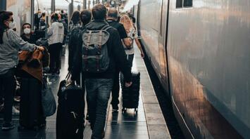 Passengers with luggage on the platform near a high-speed train