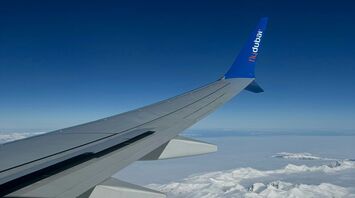 Flydubai aircraft wing over snowy mountains