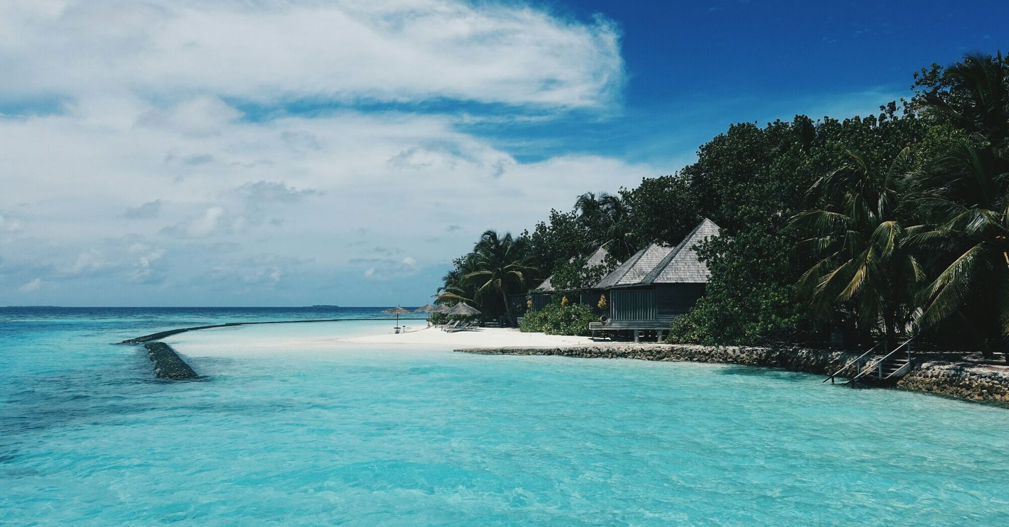 Beautiful beach in the Maldives with clear blue water and tropical huts