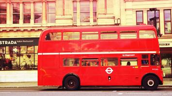 A classic red double-decker Stagecoach bus parked in front of a building with a restaurant sign