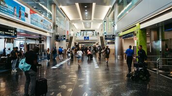 Travelers walking through Miami International Airport terminal
