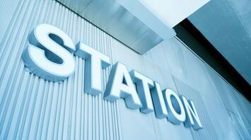 A modern station sign with a sleek, metallic design