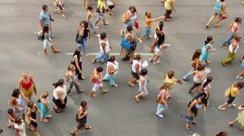 People at a mass demonstration or public event walk down the street, creating an atmosphere of unity and community