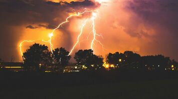 Lightning storm over a silhouetted landscape at night