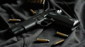 Handgun with bullets on black fabric
