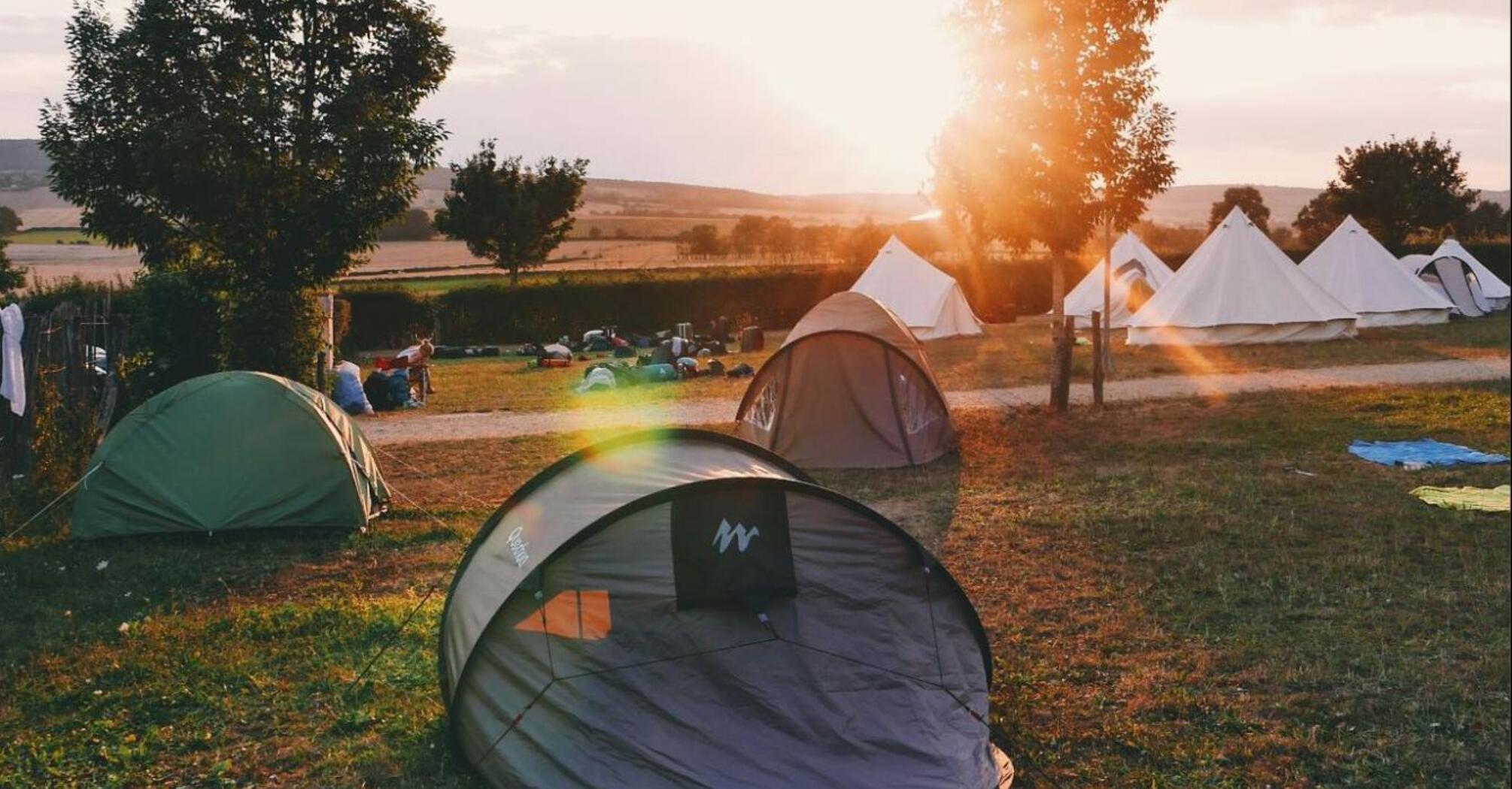 A sunrise view of tents and accommodations at a festival campsite