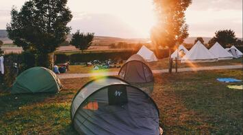A sunrise view of tents and accommodations at a festival campsite