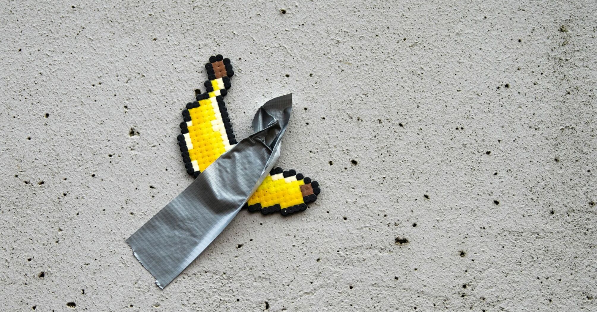 Pixel art banana taped to a wall