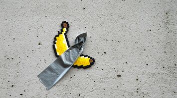 Pixel art banana taped to a wall