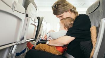 Mother with a child in her arms in the airplane cabin