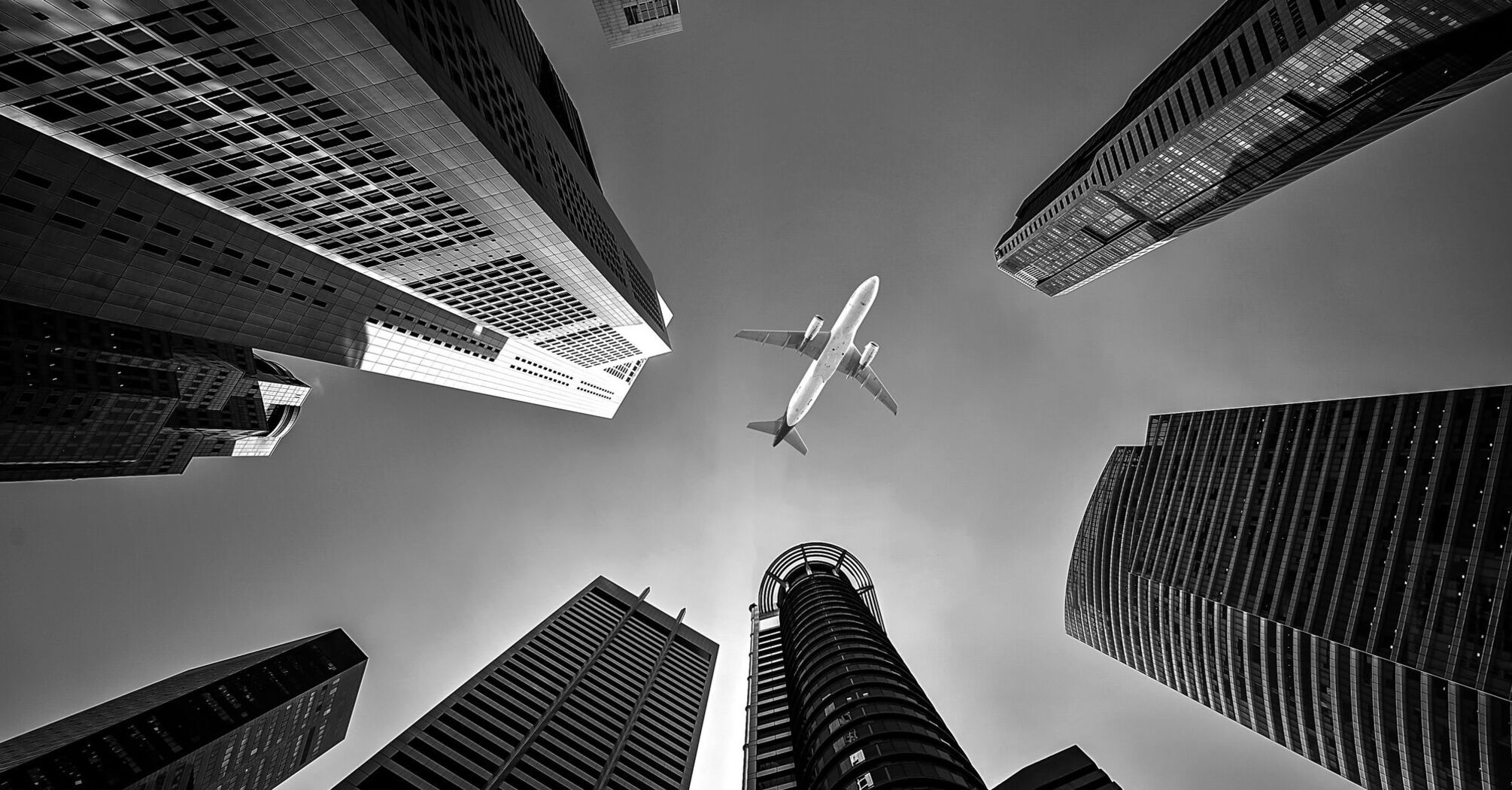 Airplane flying above city skyscrapers